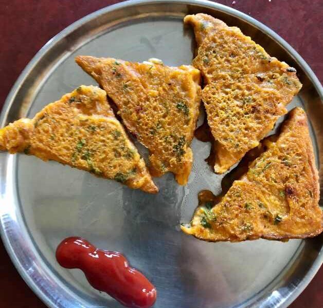 Four golden-brown Bread Pakora triangles are arranged on a stainless steel plate, served with a dollop of ketchup. The bread pakoras appear crispy and have visible flecks of herbs. The text "Bread Pakora Recipe" is overlaid on the image.